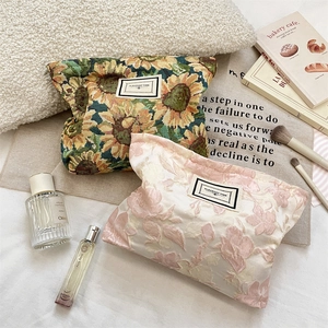Close-up of floral jacquard makeup bags with sunflower tapestry and woven fabric textures