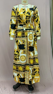 Detailed view of Baroque gold print fabric and off-shoulder waist belt on maxi dress