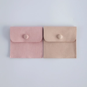 Detailed view of pink and beige velvet jewelry pouches with snap button closures