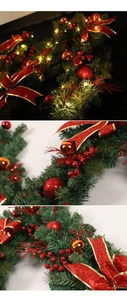 Detail of Christmas garland with LED lights, red bows, berries and orange ornaments