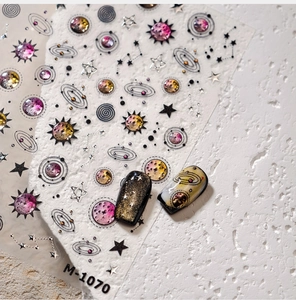 Détails macro des autocollants ongles M-1070 avec planètes argentées et motifs de galaxies