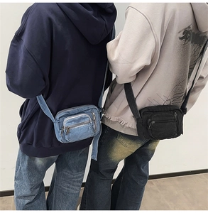 Detail shot of denim crossbody bags in blue and black with front zipper pockets