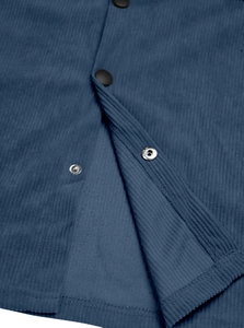 Detailed macro shot of blue corduroy fabric showing button texture and fine ribbed material