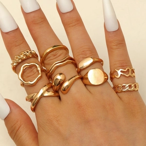 Detail eines 10-teiligen Goldminimalistischen Ringsets an den Fingern eines Models