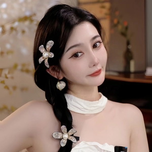 Sparkling rhinestone flower hair claw clips with pearls shown on model's hair