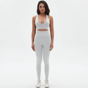 Detail of light grey seamless cross-front sports bra and high-waisted yoga leggings set