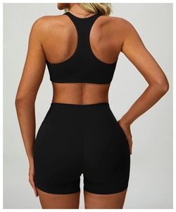 Detail of high-waist yoga shorts and racerback sports bra in matte black quick-dry fabric