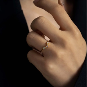 Elegant V-shaped S925 sterling silver ring with colorful opal stones worn by a model