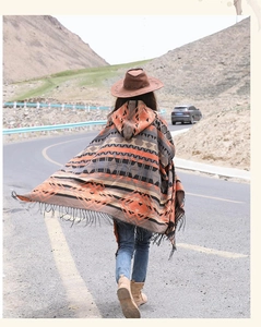 Vue extérieure d'un poncho ethnique à capuche avec motifs géométriques et franges