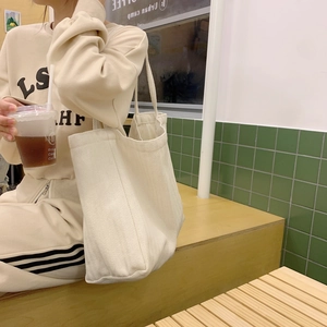 Minimalist beige canvas tote bag with large capacity for women in a lifestyle street setting