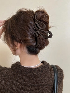 Detailed back view of a large mocha brown matte shark hair clip securing a long hair bun