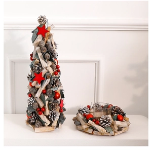 Close-up of wooden Christmas tree and wreath candle holder with pine cones and berries
