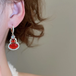 Detailed close-up of 14k gold plated gourd earrings with red stones and zircon pavé