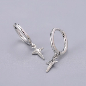 Macro shot of S925 sterling silver hoop earrings featuring polished four-pointed star charms