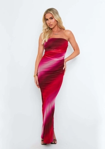 Detail of red and pink gradient strapless dress featuring side slit and ruched design