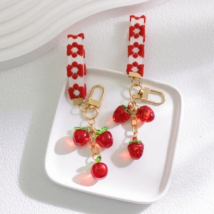 Cute strawberry fruit keychain with red and white floral embroidery and gold metal clasp