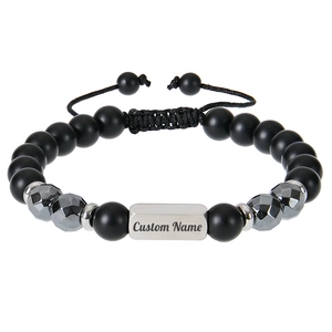 Macro detail of custom name engraving on a black matte beaded stainless steel bracelet