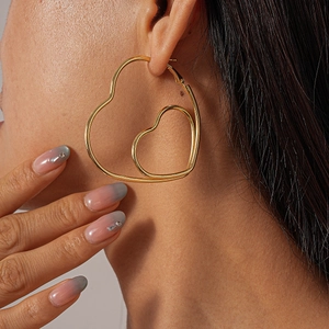 Eleganti orecchini a cerchio a doppio strato a forma di cuore in oro indossati da modella