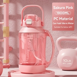 Pink 1900ml sports water bottle with straw and handle shown against gym equipment