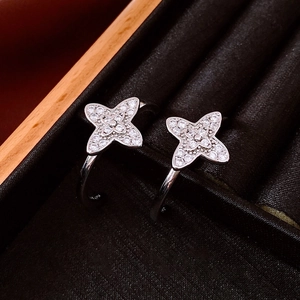 Detailed macro view of silver C-shape flower earrings with pavé-set cubic zirconia stones