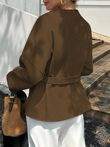 Rear view of a brown cropped jacket with a waist tie detail for casual vacation wear