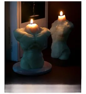 Detailansicht einer brennenden Muskel-Torso-Duftkerze in gemütlicher, kunstvoller Atmosphäre