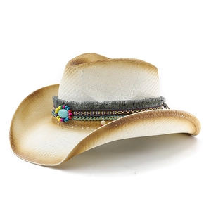 Dettaglio del cappello da cowboy in paglia intrecciata con fascia turchese e perline