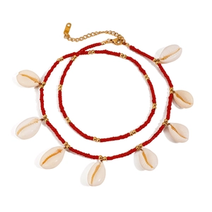 Detail of red bead anklet with white shell pendants and gold metal accents