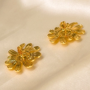 Polished 18K gold plated stainless steel sunflower earrings on silk fabric backdrop
