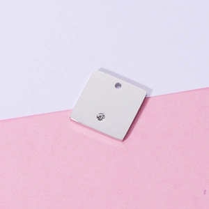 Polished silver stainless steel square pendant with inset crystal on dual-tone background