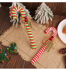 Close-up of red and white striped plush candy canes with small bells and linen bows