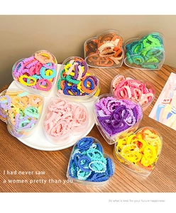 Colorful elastic hair ties for girls stored in clear heart-shaped plastic organizers