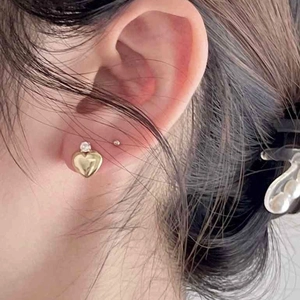 Elegant gold heart earrings with zircon inlay worn by model for a minimalist style