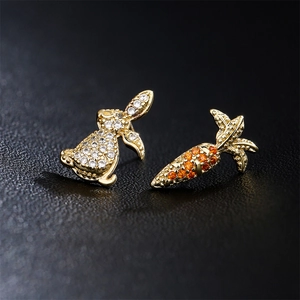 Asymmetric gold rabbit and carrot stud earrings with shimmering zircon crystals