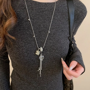 Collana lunga argentata con cuore di cristallo, cubo di marmo e nappine di metallo