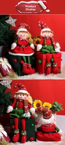 Detail of Christmas elf couple plush dolls in red and green outfits on a gift box
