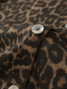 Detail of pearlescent button on high-quality leopard print knit cardigan fabric