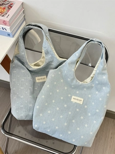 Blaue Denim-Tragetasche mit Sternen- und Schleifenmuster auf Designerstuhl