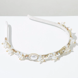 Dettaglio del cerchietto in raso bianco con perle, cristalli dorati e petali satinati