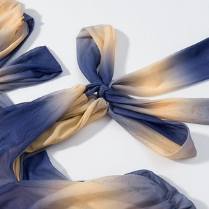 Detail of blue-yellow gradient mesh dress showing textured tie-knot and fabric quality
