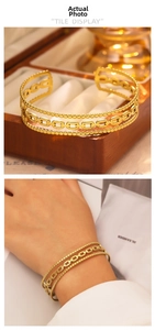 Detailed macro view of triple-layered 18k gold plated stainless steel open C-shape cuff bracelet