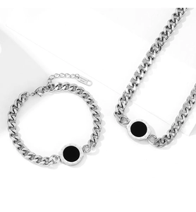 Detailed view of silver stainless steel necklace and bracelet set with roman numeral charms