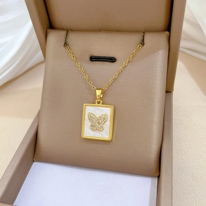 Detail of gold butterfly shell necklace displayed in a luxury velvet jewelry gift box