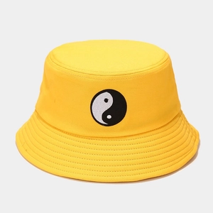 Détail d'un chapeau bob jaune en coton avec symbole Tai Chi brodé sur le devant