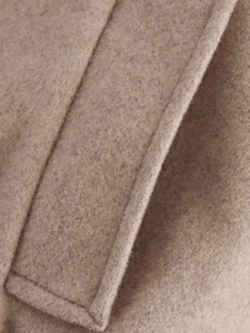 Close-up of khaki wool jacket fabric showing dense texture and fine stitching details