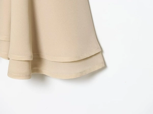 Détail de l'ourlet en georgette beige multicouche avec finition à double surpiqûre