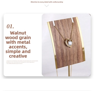Detailed view of heart pendant necklace displayed on a walnut and gold jewelry stand