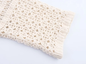 Macro detail of ivory crochet knit top showing hollow circular geometric lace pattern