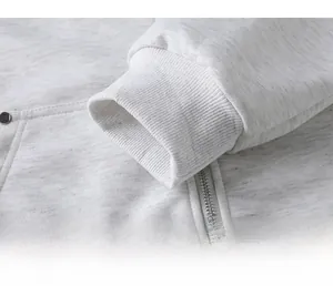 Detailaufnahme der hellgrauen Strickjacke mit elastischen Rippbündchen und Metallreißverschluss