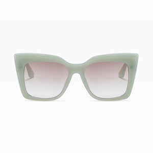 Detail of mint green cat-eye sunglasses frame with gradient pink lenses and chunky temples